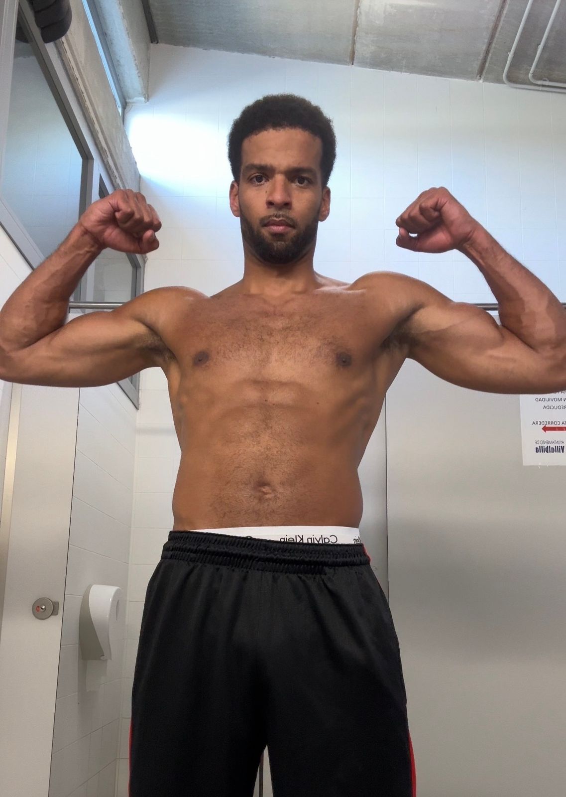 Manu today hitting a front double biceps pose, arms and abs defined